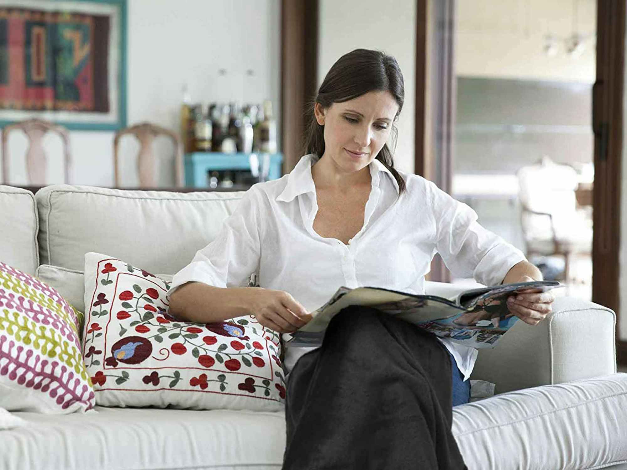 a person reading magazines on a couch