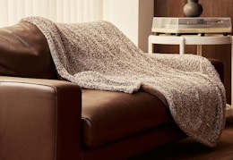 a heated plush blanket on a brown couch 