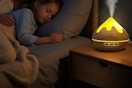 a girl sleeping next to an essential oil diffuser
