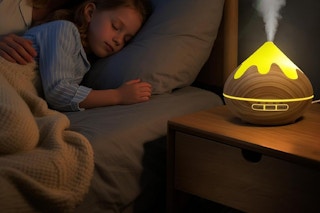 a girl sleeping next to an essential oil diffuser