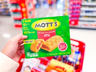 hand holding a mott's apple filled snack bar pack in front of a target shelf