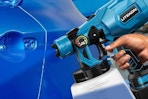 a cordless paint sprayer spraying on a car
