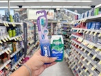 hand holding crest and oral-b items in walgreens
