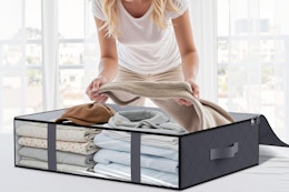 woman putting clothes in under bed storage