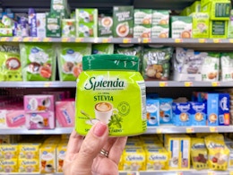 hand holding splenda stevia sweetener in walmart aisle
