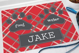 Red mat personalized with the name Jake and paw prints