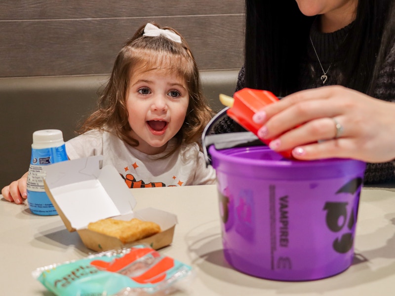 a child smiling at a mcdonalds bucket