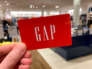 a hand holding a Gap gift card