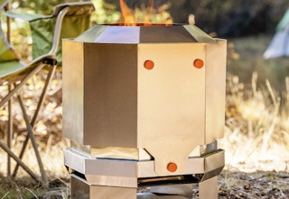 a silver fire pit in the grass