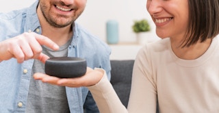 Two people talking to an Amazon Alexa device