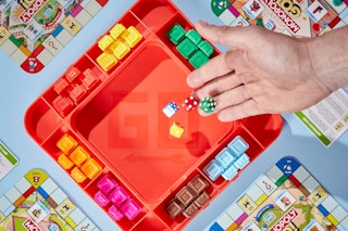 Person rolling die on the Monopoly GO! Board Game.