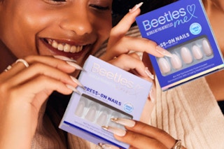 two people holding boxes of press on nails