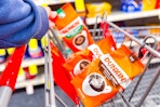 person placing bags of dunkin coffee in a cart