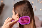 a woman using the fhi heat unbrush mini