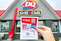 someone holding up an 85 cent blizzard flyer in front of dairy queen