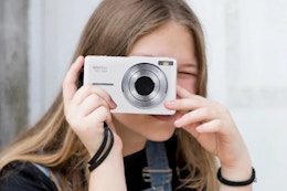person holding a white digital camera