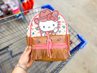 hand holding hello kitty backpack over walmart cart