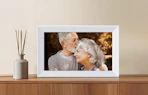 a grey digital picture frame on a wooden dresser