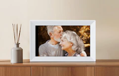 a grey digital picture frame on a wooden dresser