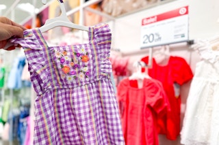 hand holding a kids' dress in the apparel department at target