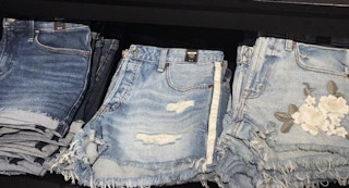 womens denim shorts folded on shelf in store at abercrombie