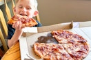 a child eating a slice of pizza 