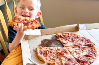 a child eating a slice of pizza 