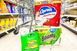 gain detergent, bounty paper towels, and charmin toilet paper in an aisle in front of a cart