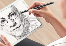 a person drawing on an iPad with a stylus pen