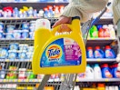 hand holding a bottle of tide simply detergent in front of walmart cart