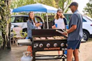 Lifestyle image of the Blackstone outdoor griddle being used by a group of people at an outdoor event