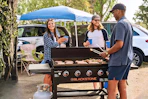 Lifestyle image of the Blackstone outdoor griddle being used by a group of people at an outdoor event
