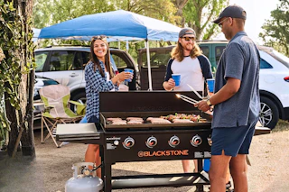 Lifestyle image of the Blackstone outdoor griddle being used by a group of people at an outdoor event