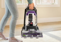person carrying the bissell carpet cleaner