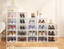 shoes in clear storage boxes stacked against a wall