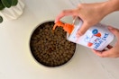 a woman using native pet fish oil on dog food