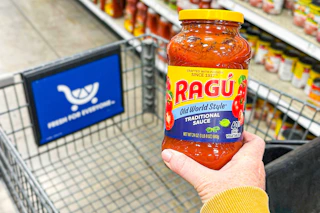 hand holding a jar of ragu pasta sauce
