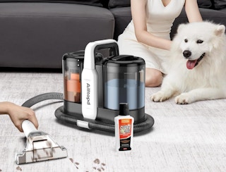 a carpet cleaner next to a dog cleaning the floor