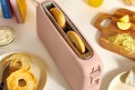 a light pink toaster with bagel slices inside