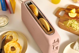 a light pink toaster with bagel slices inside