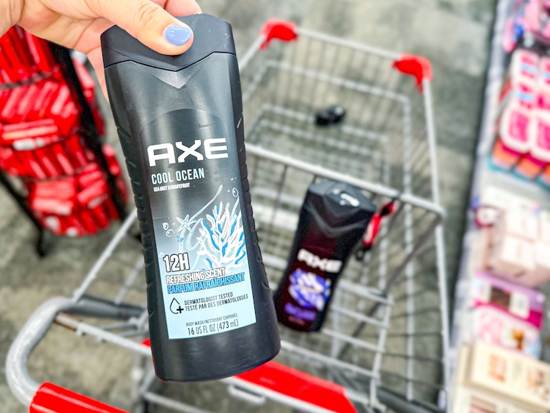 person holding axe body wash over a cart with another bottle of body wash in it