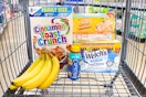 cinnamon toast crunch, bananas, capri sun, oscar mayer, welch's in a shopping cart