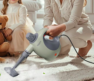 a person cleaning with a steam cleaner 