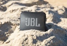 black JBL waterproof speaker in sand
