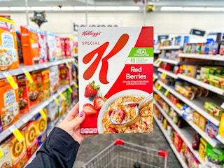 person holding a box of special k cereal in an aisle