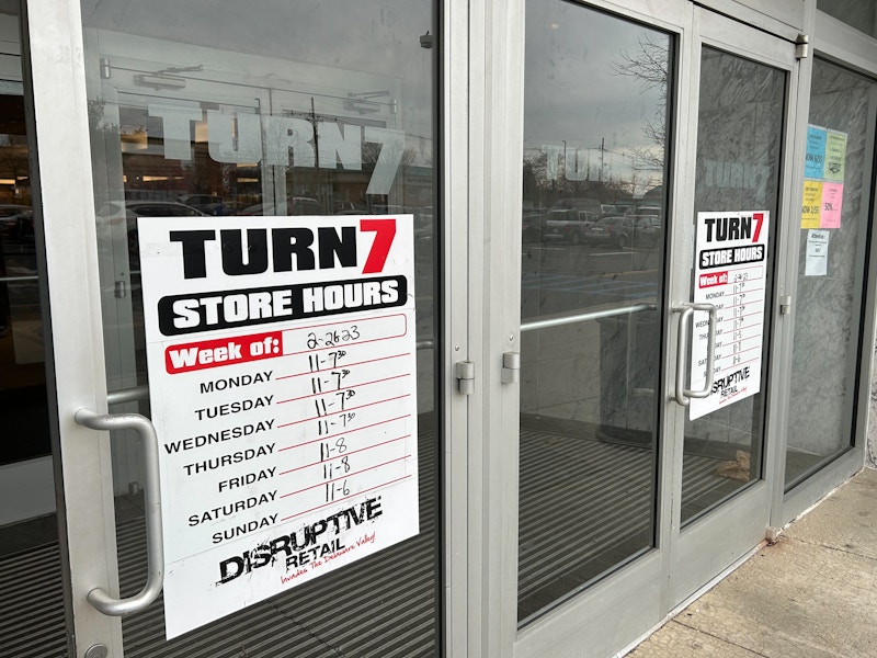 Turn7 store front entrance and hours sign posted on the window