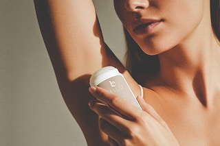 a woman using beauty by earth deodorant