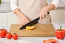 a woman using a bamboo cutting board