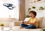 a kid on a couch playing with a drone