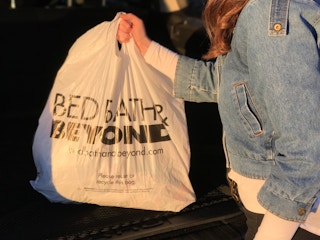 A person holding a Bed Bath and Beyond bag.